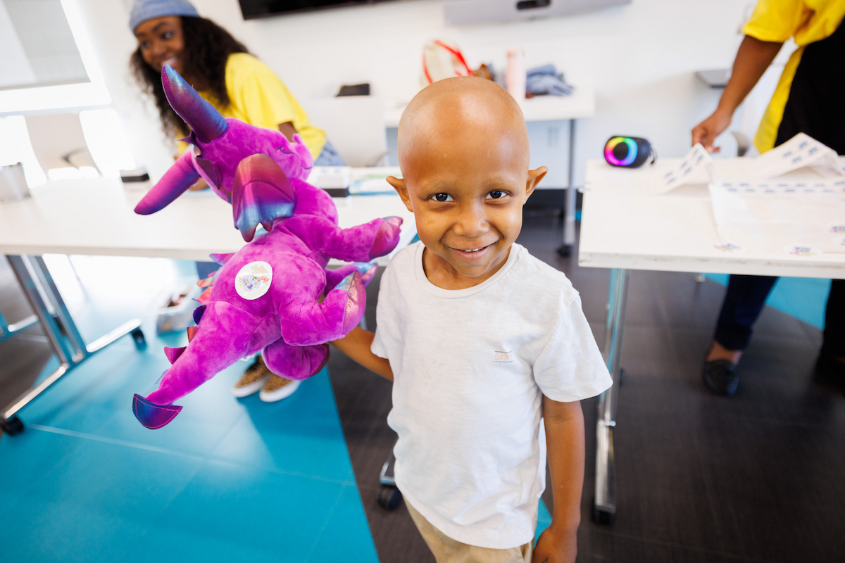 Caleb Wiley, 4, is all smiles with his new stuffed dragon during Toot, Teach and Roll's annual Furry Friends event.